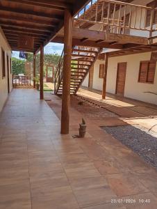 an empty patio with a wooden roof and stairs at pousada mar e vento in Touros