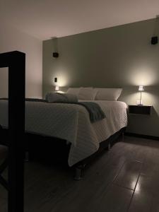 a bedroom with a bed with two lamps on it at 7min del Parque Central-2min Rotonda Marimba, en la naturaleza Tipo LOFT5 in Quetzaltenango