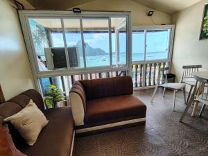 a living room with a couch and a large window at Gracias Place in El Nido