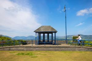 a man walking a bike next to a gazebo at Montford Shore in Rothesay