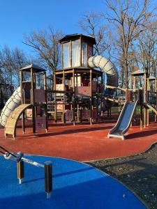 a playground with a slide in a park at Boruzs Apartman in Hajdúszoboszló
