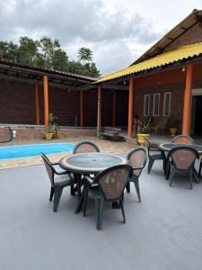 a patio with tables and chairs next to a pool at Casa Calleb in Presidente Figueiredo