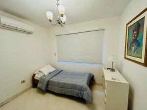 a bedroom with a bed and a white wall at Carmen Magdalena in Asunción