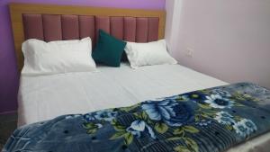 a bed with two pillows and a blanket on it at Hotel Dharma palace in Prayagraj