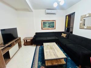 a living room with a black couch and a flat screen tv at Carmen Magdalena in Asunción