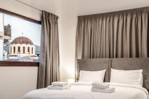 a hotel room with a bed with towels on it at Ermou Residences in Volos