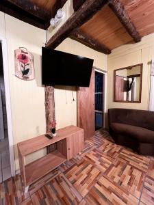 a living room with a flat screen tv on the wall at Kutral-Ko in Hornopiren