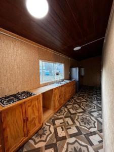 a kitchen with wooden cabinets and a sink and a window at Kutral-Ko in Hornopiren