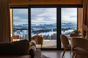 a room with a large window with a view of the mountains at Góralska Dolina II Jacuzzi & Sauna in Zakopane