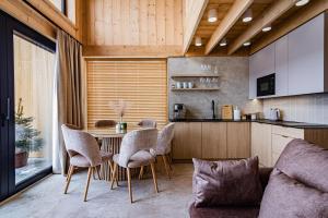 a kitchen with a table and chairs and a couch at Góralska Dolina II Jacuzzi & Sauna in Zakopane +244 photos