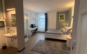 a bedroom with a bed and a bathroom with a sink at JOSEFS Gasthaus Sibille in Schlangen