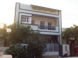 a large white building with balconies on it at Raina's Home in Bhuj