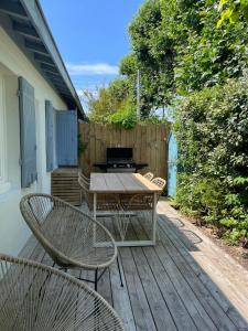 a patio with a table and chairs on a deck at Andernos les pieds dans l eau in Andernos-les-Bains