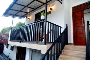 a house with a staircase and a red door at AERO View Villa in Induruwa