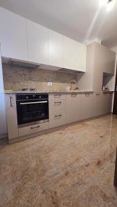 a kitchen with white cabinets and a stove at Downtown City Apartment in Râmnicu Vâlcea