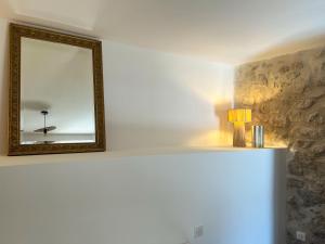 a mirror sitting on a shelf in a room at Le Moulin de Lauve in Saint-Hilaire-les-Courbes