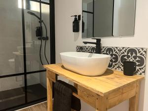 a bathroom with a white bowl sink on a wooden table at Le Moulin de Lauve in Saint-Hilaire-les-Courbes +22 photos