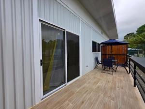 a patio with a table and an umbrella on a deck at Sunshine at Life's a Beach in Uvita