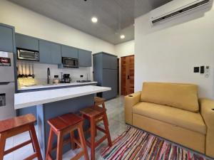 a living room with a couch and a kitchen at Sunshine at Life's a Beach in Uvita