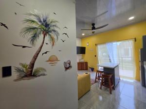 a living room with a palm tree on the wall at Sunshine at Life's a Beach in Uvita