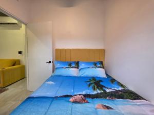 a bedroom with a bed with a blue comforter at Sunshine at Life's a Beach in Uvita +24 photos
