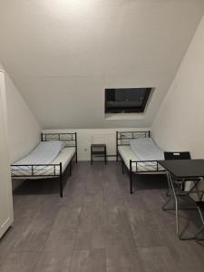 a room with two beds and a tv on the ceiling at modernes & einfaches übernachten in Bruchsal