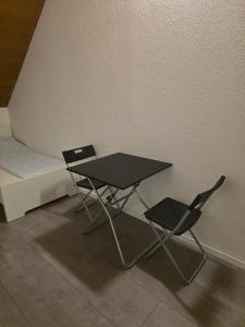 a table and two chairs next to a bed at modernes & einfaches übernachten in Bruchsal