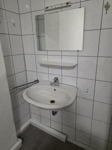 a bathroom with a white sink and a mirror at modernes & einfaches übernachten in Bruchsal