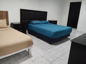 a bedroom with two beds with blue pillows at Casa pame 2026 in Mérida