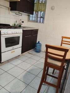 a kitchen with a stove and a table and chairs at Casa pame 2026 in Mérida +11 photos