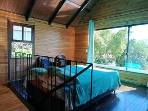 a bedroom with a bed and a large window at Casa da Lagoa perto do Mar in Pescaria Brava