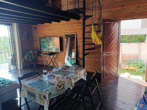 a dining room with a table and chairs and a television at Casa da Lagoa perto do Mar in Pescaria Brava