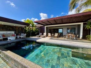a house with a swimming pool and a patio at Coral Villa in Cap Malheureux