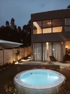a house with a swimming pool in front of a house at Casa com piscina aquecida, estilosa e privativa in Nazaré Paulista