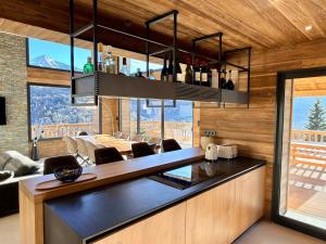 a kitchen with a counter with chairs and a table at Chalet 1480 in Allos