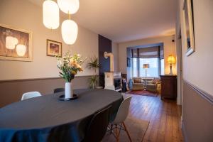 a dining room table with a vase of flowers on it at Villa Ker Betsy in Dinard