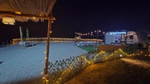 a fence with lights in the snow at night at Happy dreams in Ramlah +5 photos