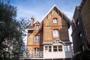 a large red brick building with a white porch at Villa Ker Betsy in Dinard