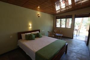 a bedroom with a bed and a table and chairs at Green Heaven in Dickwella