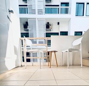 a dining room with white chairs and a table at The Sunset Bangsaen in Ban Rong Khoei