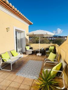 an outdoor patio with chairs and an umbrella at La Vida Bonita in El Verger +3 photos