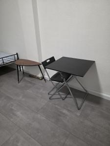 a black table and a chair in a room at modernes & einfaches übernachten in Bruchsal