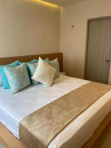 ein großes Bett mit blauen und weißen Kissen darauf in der Unterkunft Techos Azules in Taganga