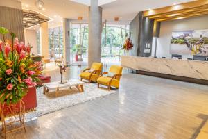 a lobby with yellow chairs and a reception desk at GHL Hotel Neiva in Neiva