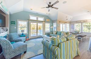 a living room with blue and white furniture and windows at Family Tradition - Duck Landing, Oceanside, 130 Yds to Beach, Pool, Hot Tub, Tiki Bar in Duck