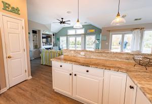 a kitchen with white cabinets and a counter top at Family Tradition - Duck Landing, Oceanside, 130 Yds to Beach, Pool, Hot Tub, Tiki Bar in Duck +54 photos