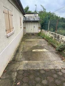 an empty alleyway next to a building with a gate at maison indépendante in Millery