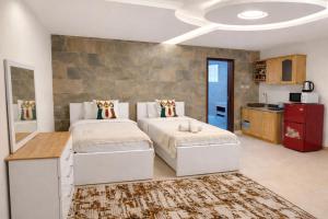 a bedroom with two beds and a kitchen at Sky Suites East Legon in Accra