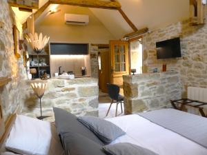 a bedroom with a bed and a stone wall at Studio Natur'ailes, Le Hameau du Quercy, romantique, campagne, piscine naturelle in Frontenac