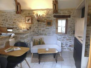 a living room with a couch and a table at Studio Natur'ailes, Le Hameau du Quercy, romantique, campagne, piscine naturelle in Frontenac